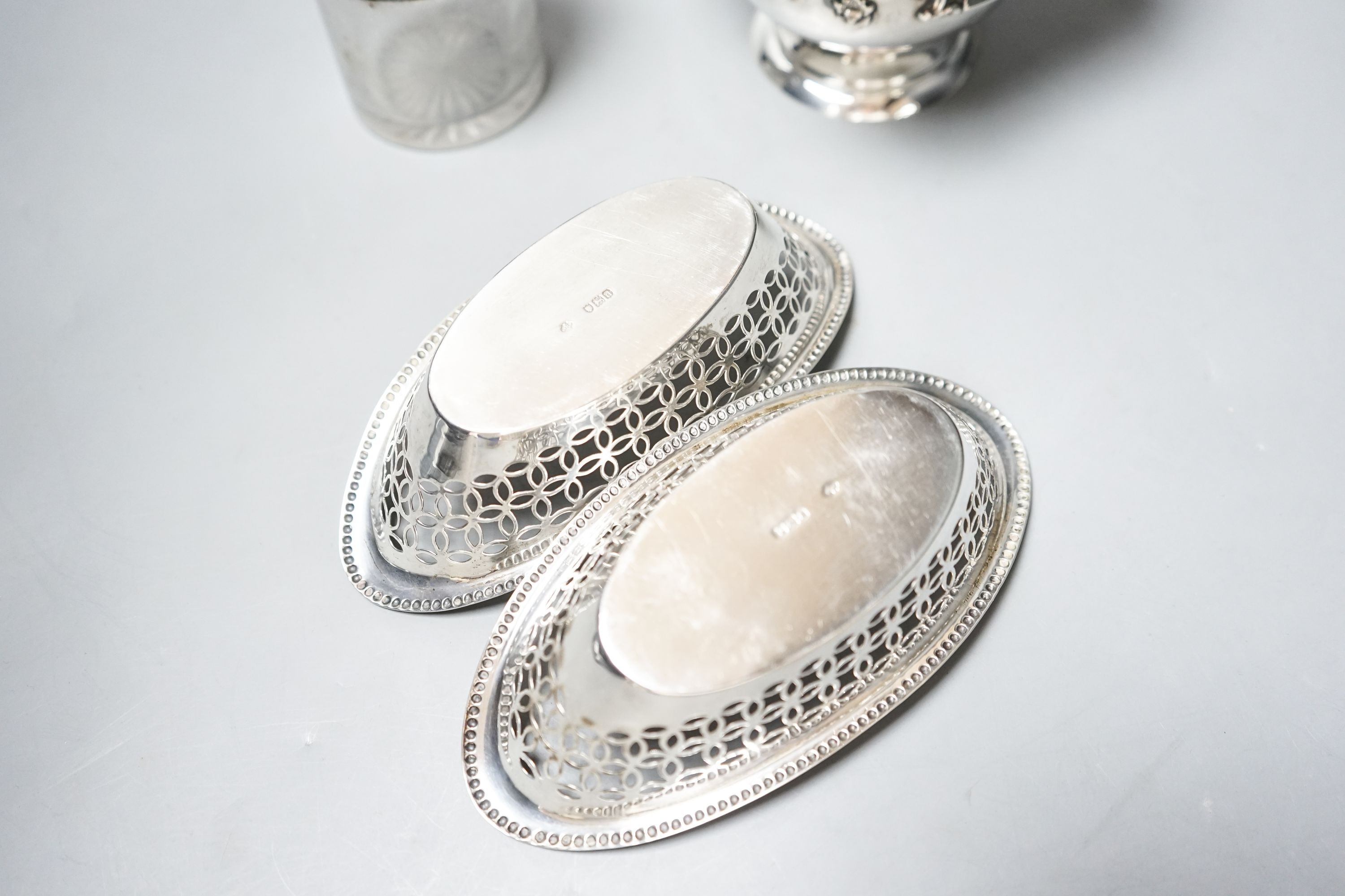 A pair of Edwardian silver oval bon bon dishes, a George V silver sugar bowl and a silver mounted glass smelling salts bottle.